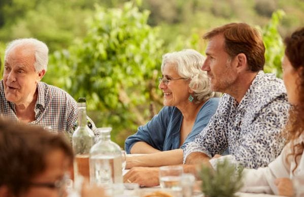 Photo of older people seated outdoors at lunch.