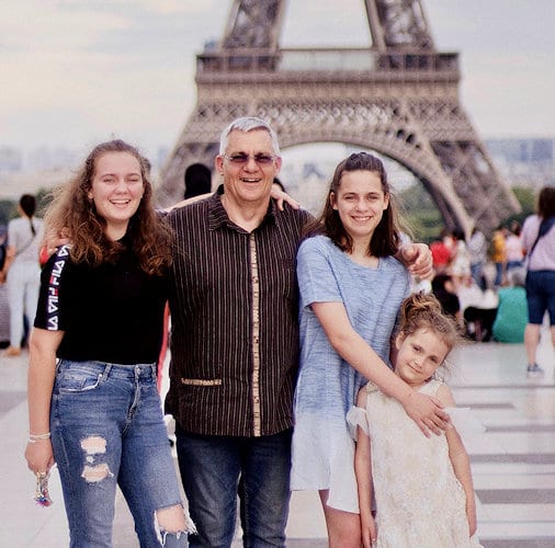 Beginner Traveler Photo of dad and his three daughters in front of Eiffel Tower