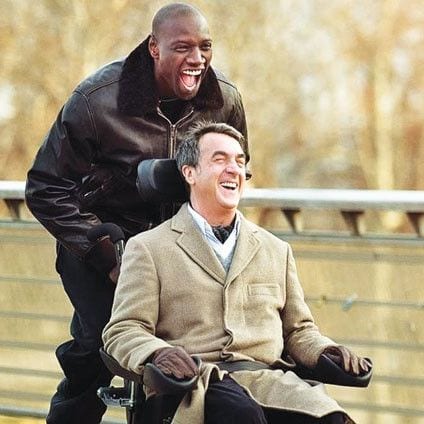 Image of Omar Sy pushing François Cluzet in wheelchair. Scene in French movie "Untouchables"