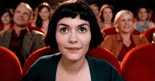 Actor Audrey Tatou sitting in a movie theater, still from Amelie